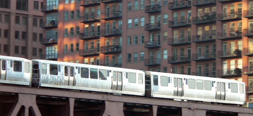 An elevated train passes in front of apartments in Chicago.