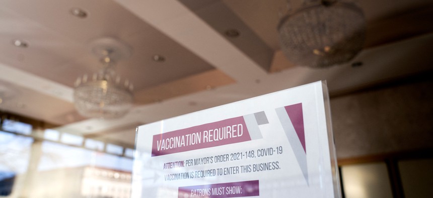 A sign requiring attendees to show proof of their Covid-19 vaccination is displayed in the doorway of the National Theatre in Washington, DC, on January 17, 2022. 