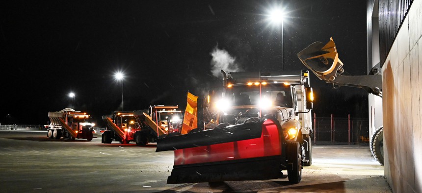 Snow plows are lined up to get topped off with salt at the South Portland Public Works in Maine, as the snow begins to come down in February of 2021. Snow plowing is one field where governments have seen worker shortages in recent months.