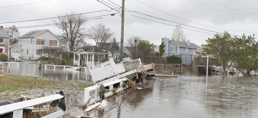 A flooded street in an oceanside community shows the power of Hurricane Sandy, a powerful storm which crashed into the Eastern USA. A porch which has been torn off of a house lies in the flooded street.