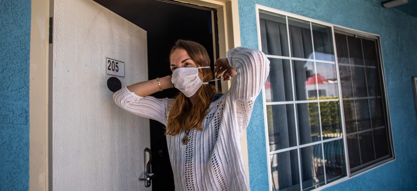 A participant in the Project Roomkey program in California, outside a motel room in April 2020.
