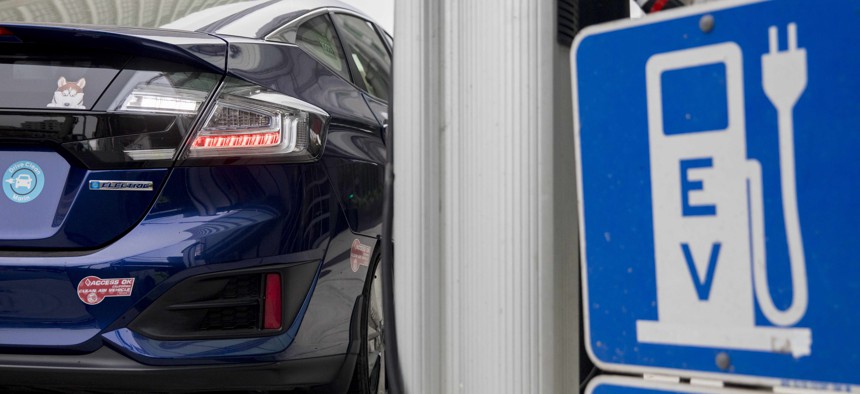A driver fuels her all-electric vehicle at a public charging station in San Francisco, Calif.