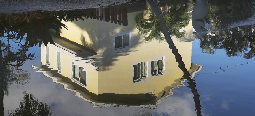 A house is reflected in a street flooded with ocean water in Key Largo, Florida in 2019.