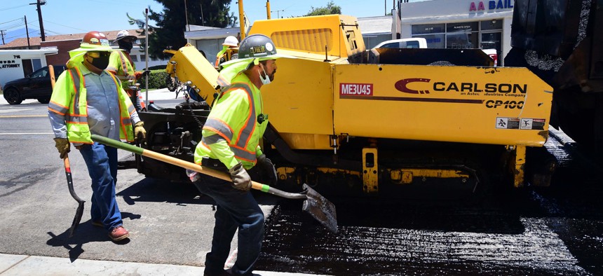 A crew works to resurface a road in Alhambra, California in June 2021.