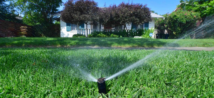 An automated sprinkler waters grass in front of homes in Alhambra, California on April 27, a day after Southern California declared a water shortage emergency with unprecedented new restrictions on outdoor watering for millions of people living in Los Angeles, San Bernardino and Ventura counties. 