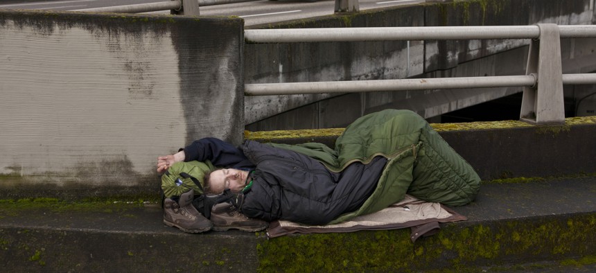 A homeless man sleeps on a downtown roadway overpass in Portland, Oregon. 