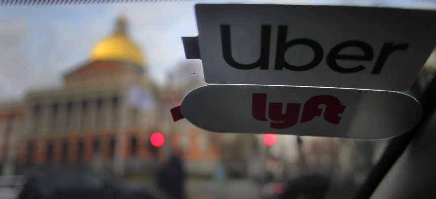 Uber and Lyft stickers are pictured inside a ride share vehicle outside the Massachusetts State House in Boston.