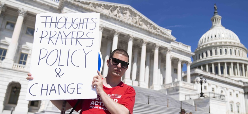 A demonstrator holds a sign referencing calls for legislation to address gun violence is seen outside the U.S. Capitol on Thursday, June 9, 2022.