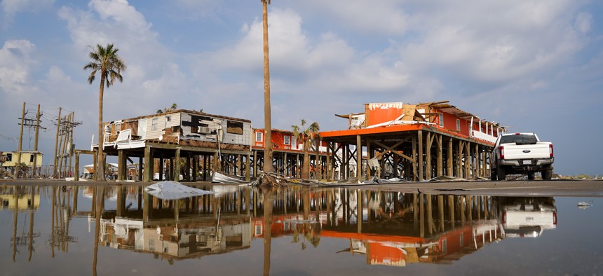 Storm damaged houses are reflected in flood water after Hurricane Ida on September 3, 2021 in Grand Isle, Louisiana.