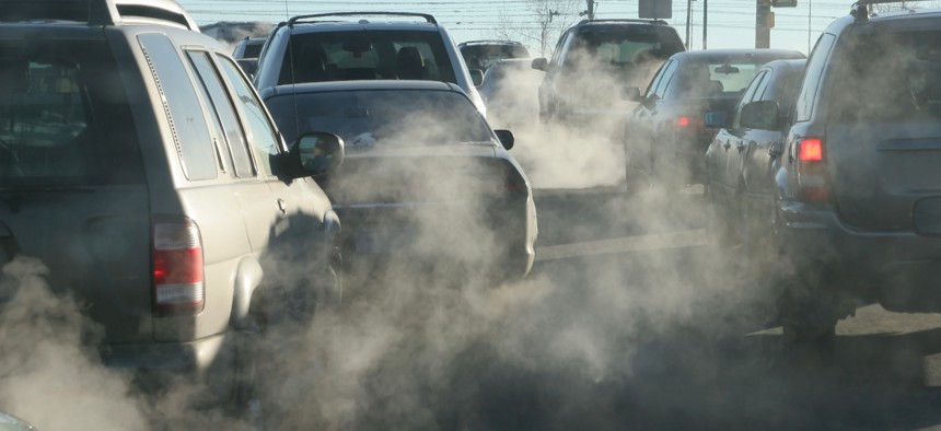 At an intersection in Denver, Colorado, exhaust pours out of a tailpipes from accelerating vehicles onto Santa Fe Drive.
