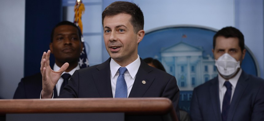 Transportation Secretary Pete Buttigieg (C) speaks during a news conference marking six months since the signing of the bipartisan infrastructure bill at the White House in May.