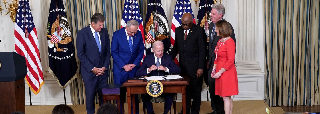 U.S. President Joe Biden (C) signs H.R. 5376, the Inflation Reduction Act of 2022, in the State Dining Room of the White House in Washington, DC, on August 16, 2022. - Also pictured (L-R) are US Senator Joe Manchin (D-WV), US Senate Majority Leader Chuck Schumer (D-NY), House Majority Whip James Clyburn (D-SC), US Representative Frank Pallone (D-NJ), and US Representative Kathy Castor (D-FL).