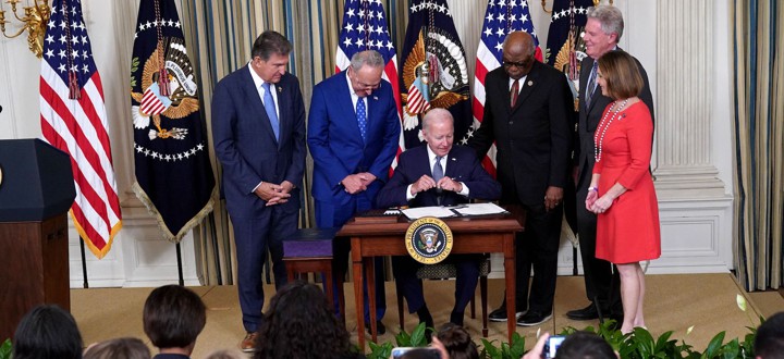 U.S. President Joe Biden (C) signs H.R. 5376, the Inflation Reduction Act of 2022, in the State Dining Room of the White House in Washington, DC, on August 16, 2022. - Also pictured (L-R) are US Senator Joe Manchin (D-WV), US Senate Majority Leader Chuck Schumer (D-NY), House Majority Whip James Clyburn (D-SC), US Representative Frank Pallone (D-NJ), and US Representative Kathy Castor (D-FL).