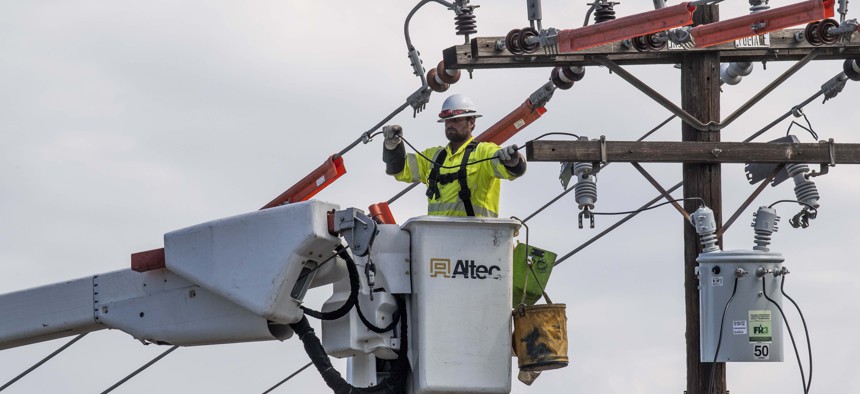 Workers with Southern California Edison replace a transformer on Holt Street in Santa Ana, California.