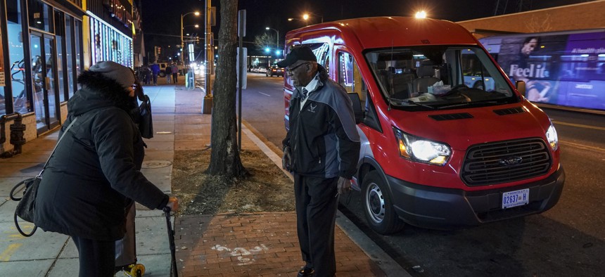 WASHINGTON, DC - Debra Dezon, left, approaches driver John Scott for a ride along the Georgia Avenue route of DC's microtransit services system in January 2018.