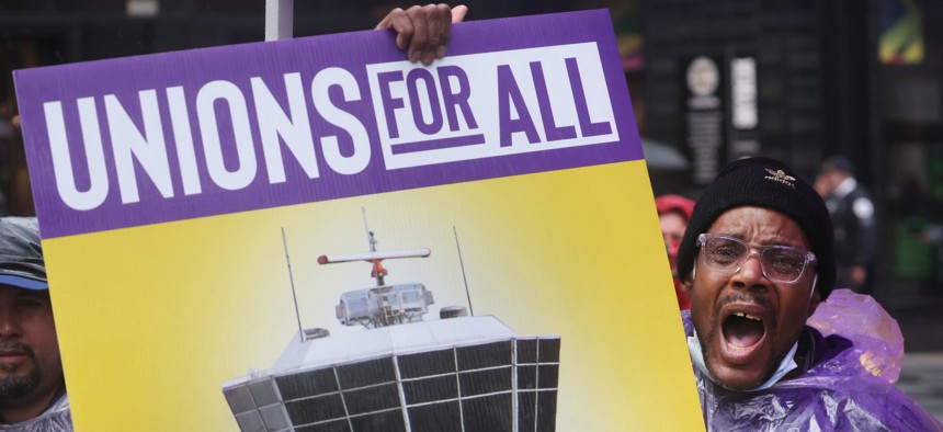 Airport workers participate in a rally organized by the Service Employees International Union (SEIU) outside of the Willis Tower headquarters of United Airlines on March 30, 2022 in Chicago, Illinois.