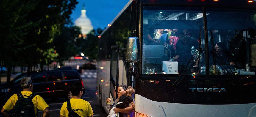 WASHINGTON, DC - Migrants disembark a bus from Texas within view of the U.S. Capitol on Thursday, Aug. 11, 2022.
