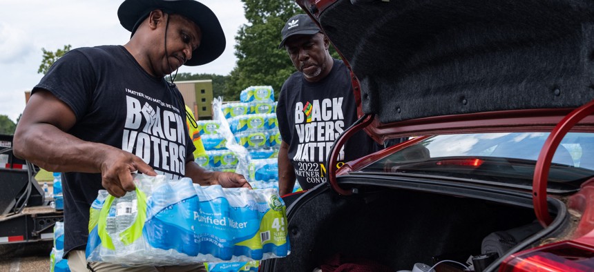 Residents distribute cases of water at Grove Park Community Center in Jackson, Mississippi, on September 3, 2022.