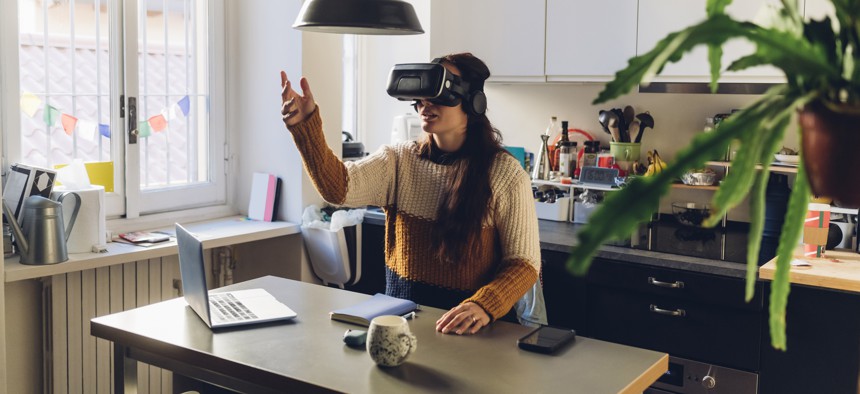 Woman gesturing wearing virtual reality headset at home.