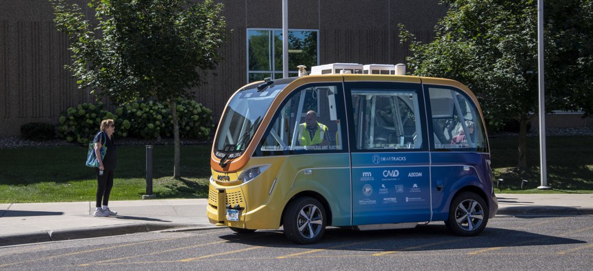 A woman waits to ride on the self-driving low speed multi-passenger electric shuttle, called Bear Tracks, in White Bear Lake, Minnesota. 
