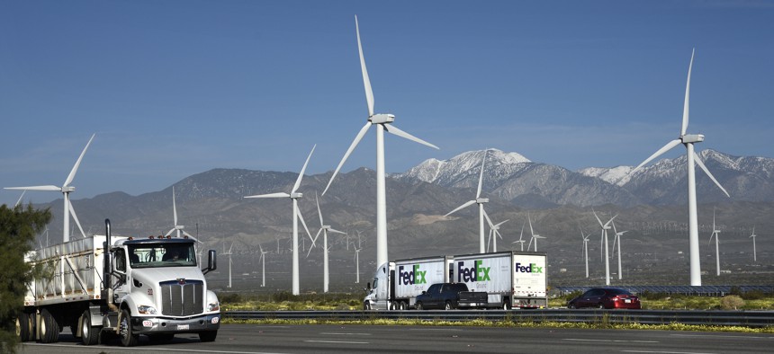 Trucks and other vehicles travel along Interstate 10 as wind turbines generate electricity at the San Gorgonio Pass Wind Farm near Palm Springs, California.