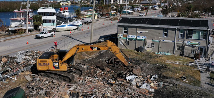 An excavator is used to clear debris on San Carlos Island, Florida, in the wake of Hurricane Ian on Oct. 6, 2022. 