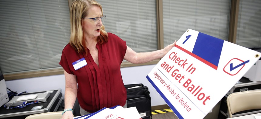 Volunteer election workers Lisa K. Jordan works to assemble voting instructional signs at the Robert L. Gilder Elections Service Center on August 5, 2022 in Tampa, Florida.