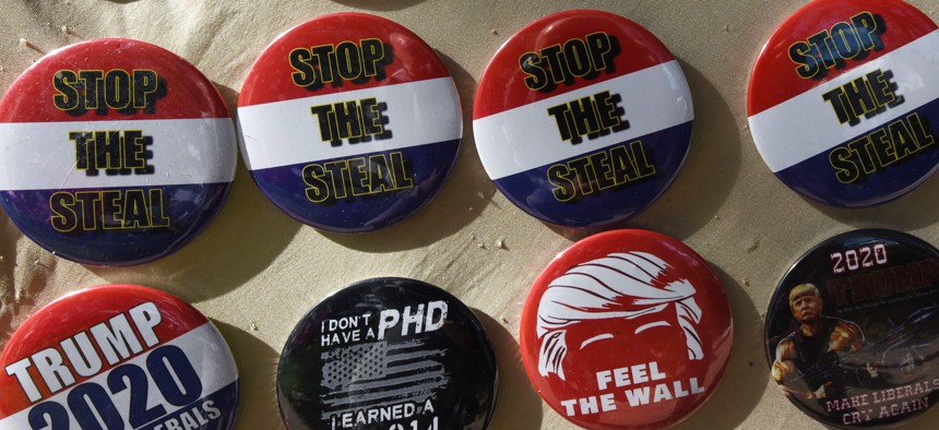 Badges saying "Stop the Steal" are seen for sale outside the 2021 Conservative Political Action Conference. The slogan was adopted by those who embraced the false claim that Donald Trump won the 2022 presidential election.
