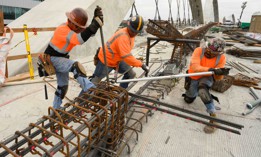 Three ironworker rodbusters twist rebar for a barrier wall during the construction of the new 6th Street Bridge on May 17, 2022 in Los Angeles, California. 
