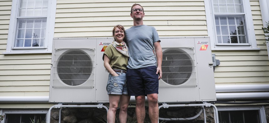 A Massachusetts couple with the heat pumps they had installed in their home.