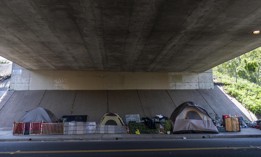 A homeless encampment of tents neatly sit underneath the I-5 freeway in Sacramento, California Sunday April 3, 2022.