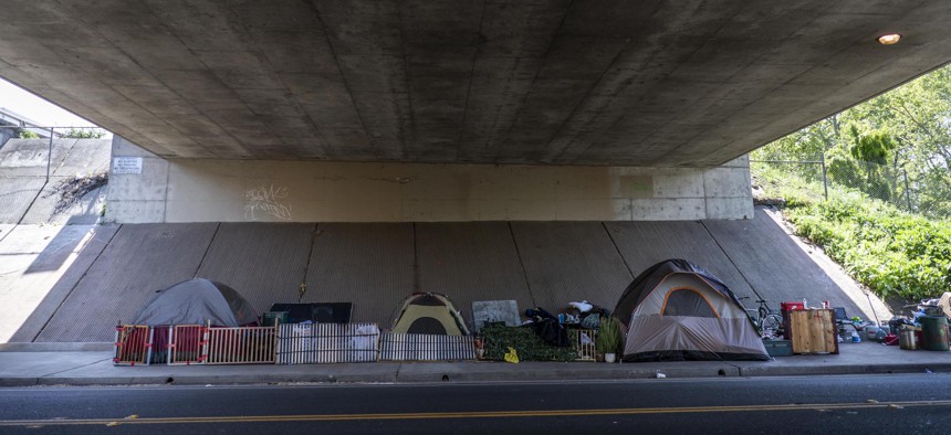 A homeless encampment of tents neatly sit underneath the I-5 freeway in Sacramento, California Sunday April 3, 2022.