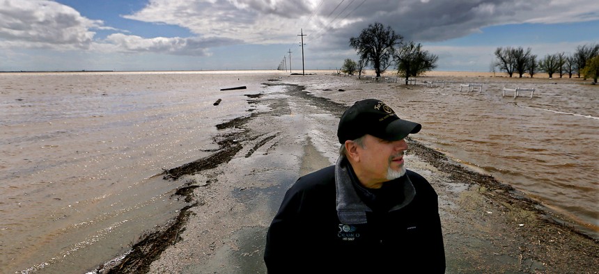 Agribusiness consultant Mark Grewel stands on a farm road that was flooded near Corcoran, California, earlier this year. 