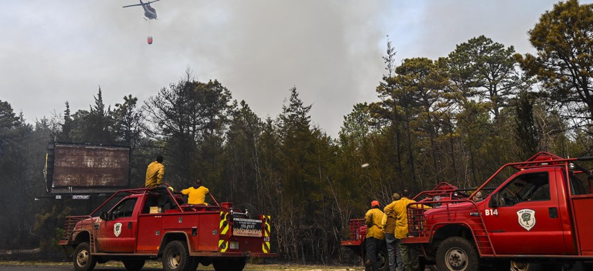 Firefighters work to control a forest fire near Manchester, New Jersey on April 12, 2023.