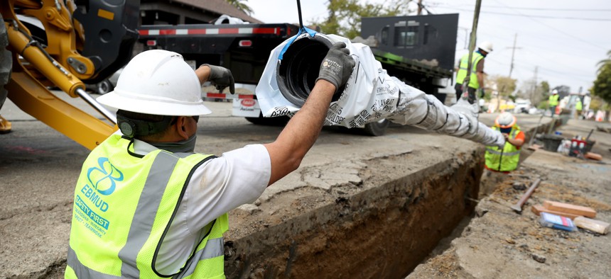 Workers with East Bay Municipal Utility District (EBMUD) install new water pipe in Oakland, California, in 2021. 
