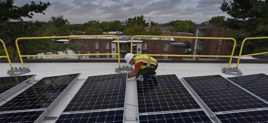 Naomi Hawk works on a job site installing solar panels on the roof of an apartment complex in Washington D.C. in 2019.