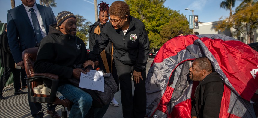 Los Angeles Mayor Karen Bass, center, chats with houseless living under tents behind Academy Museum of Motion Pictures in February. 