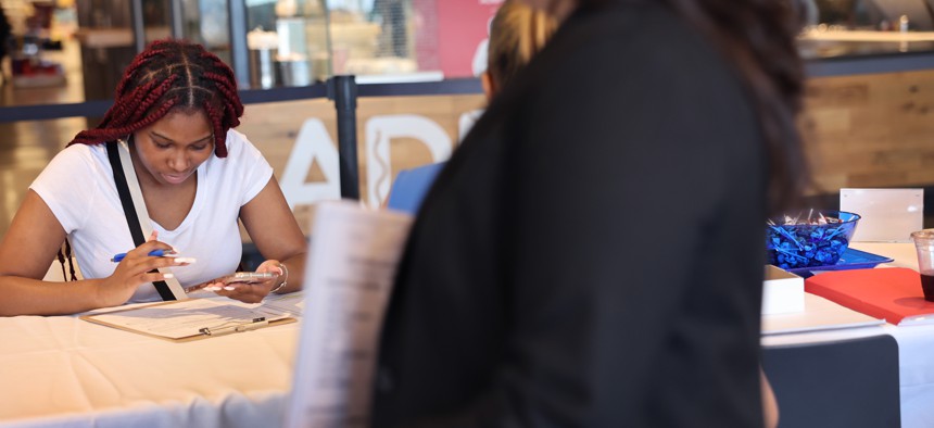 A job seeker fills out an application during a job fair. Individuals with convictions face more barriers to employment.