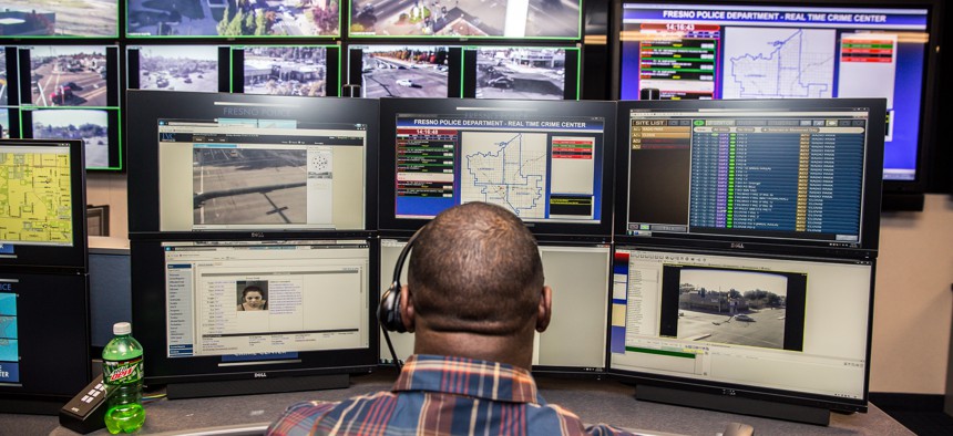 Fresno Police officers can be seen inside the Fresno Police Department's real time crime center manning computers.