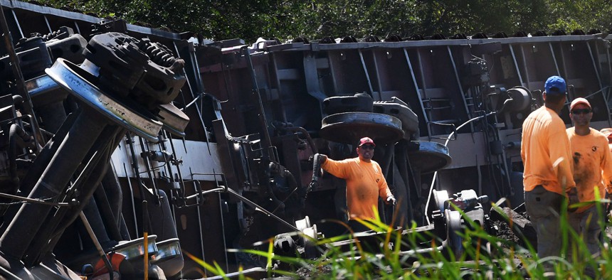 Workers clear the tracks after a Seminole Gulf Railway train derailed yesterday causing six train cars to overturn near Sarasota-Bradenton International Airport in Florida on March 1.