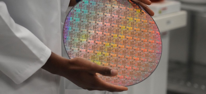 An employee holds a silicon wafer with chips etched into it in Sunnyvale, California, earlier this year. 