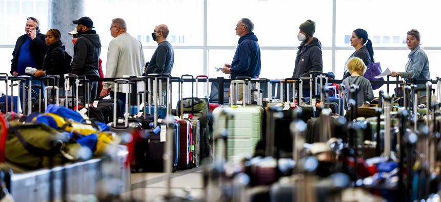 Travelers wait in line before they are allowed to search for their luggage in a baggage holding area for Southwest Airlines at Denver International Airport in December 2022.