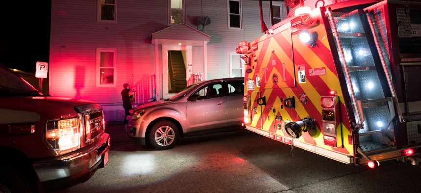 A young woman, who made an emergency call to 911, waits outside her apartment building as fireman try to revive a friend who had overdosed in Manchester, New Hampshire.