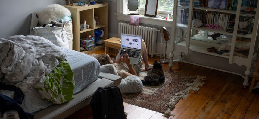 A teenager multitasks in her room, using both a computer and a cell phone to connect with the world, June 2, 2021 in Brooklyn, New York.
