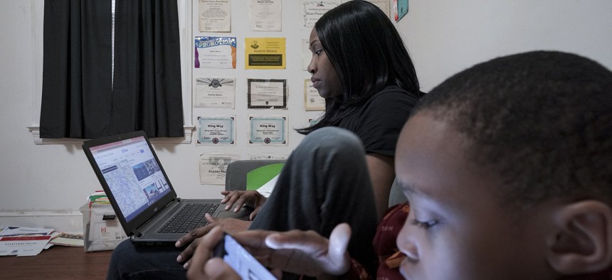 Nisa Harper searches rental listings while spending time with her son, River-Phoenix Moten, 9, earlier this year in Washington, D.C.