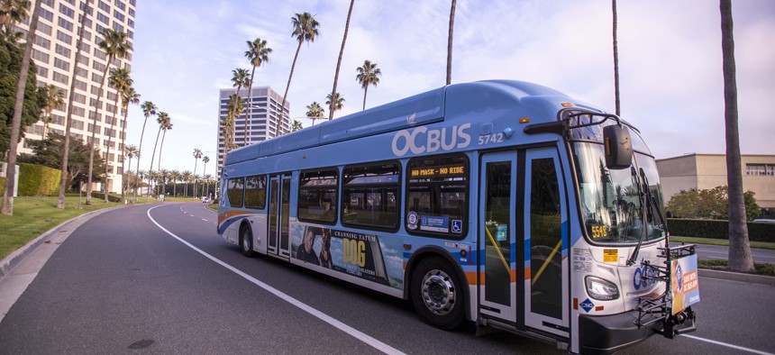A bus driver drives an Orange County Transportation Authority bus in Newport Beach in February 2022.