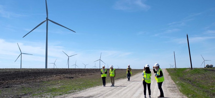 Employees of the utility company Engie walk down a road for a closer look at wind turbines during a tour of the Limestone Wind Project in Dawson, Texas, on February 28, 2023. 