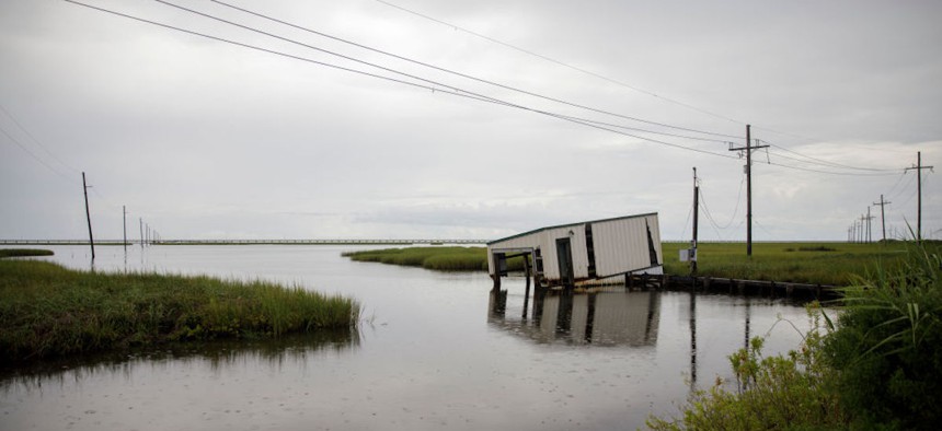   A fishing dock dips into coastal waters near Bayou Lafourche in Leeville, Louisiana, on Aug. 25, 2019. According to researchers at the National Oceanic and Atmospheric Administration, Louisiana's combination of rising waters and sinking land give it one of the highest rates of relative sea level rise on the planet. 