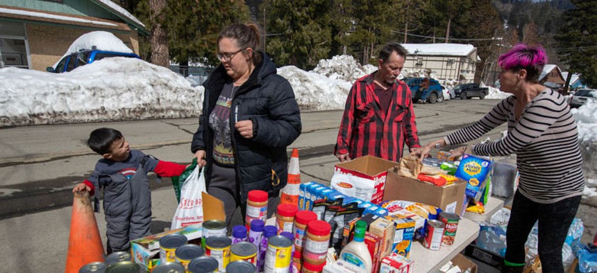 Residents gather food and supplies from a volunteer food pantry in the San Bernardino Mountain community in California on March 7, 2023.