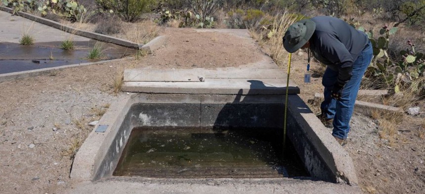 A volunteer with the Arizona Game and Fish District checks the levels of a wildlife water catchment in Green Valley, Arizona, on July 27, 2023. The catchment, which usually relies on rainwater supply, had to be refilled manually due to continued drought conditions.